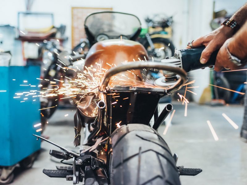 Mature man, working on motorcycle in garage
