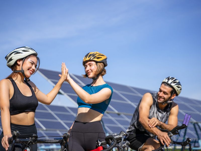 People are exercising near solar powerplant. Work out and environment.